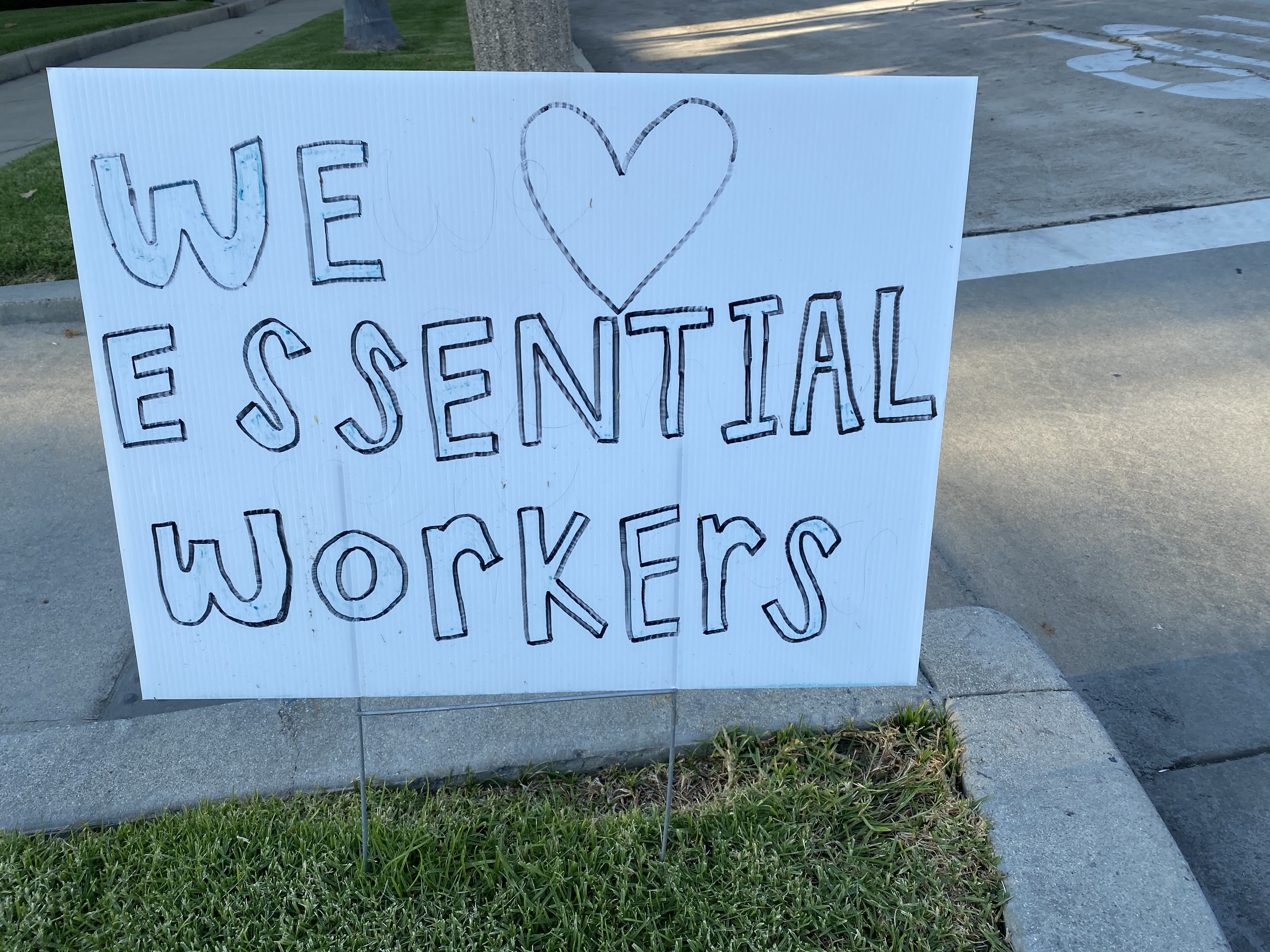 Home made Sign that says we love our essential workers. 